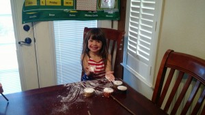 Ava's cupcakes and the handful of sugar she is about to lick from her hand